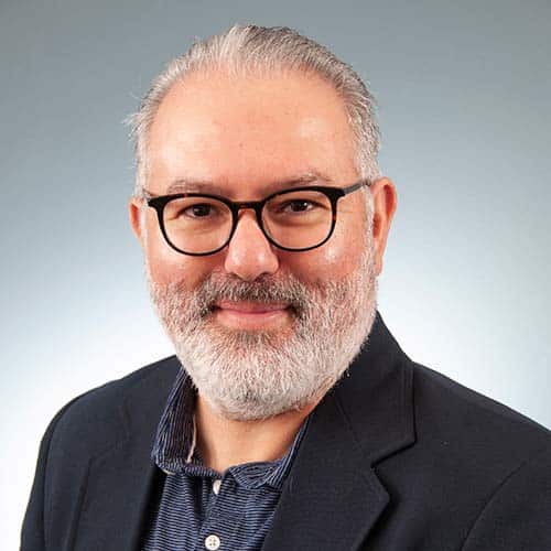 a man wearing glasses posing for the camera