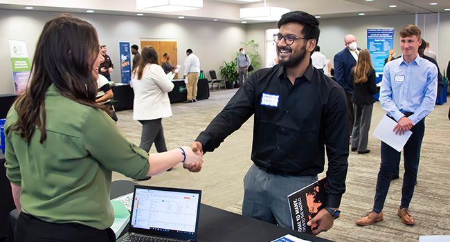 a group of people standing next to a laptop