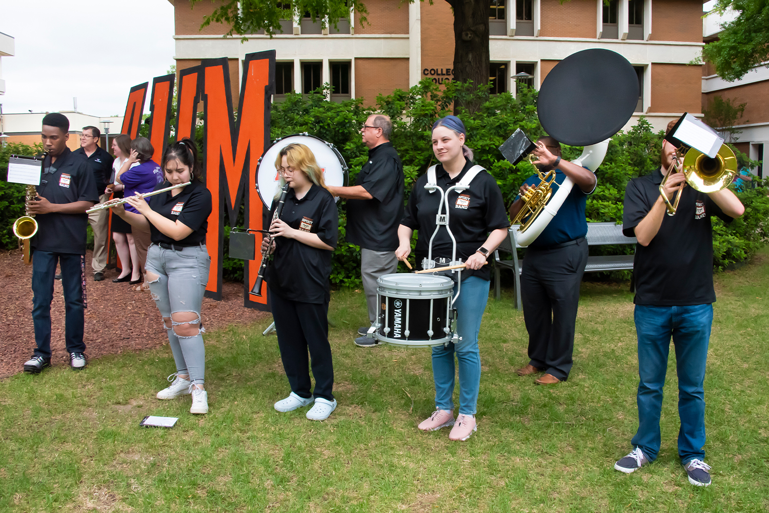 a group of people that are standing in the grass