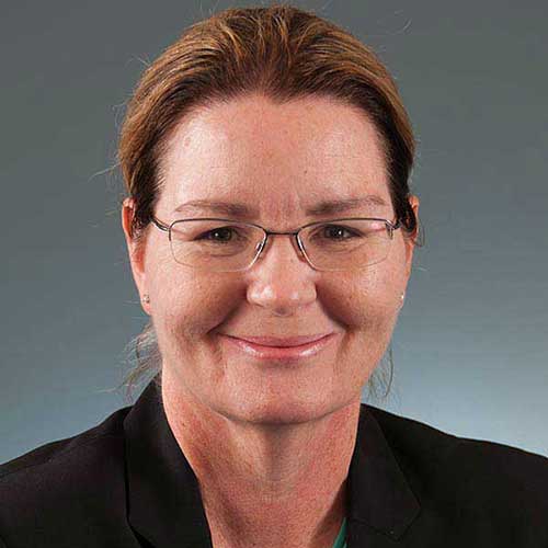 a man wearing glasses and smiling at the camera