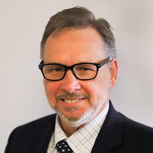 a man wearing glasses and a suit