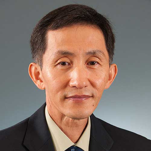 a man wearing a suit and tie smiling at the camera