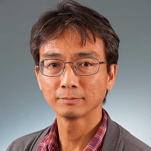 a man wearing glasses and smiling at the camera