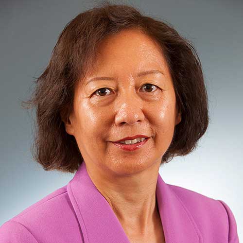 a person wearing a purple shirt and smiling at the camera