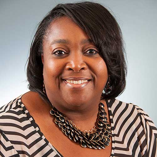 a woman in a striped shirt and smiling at the camera