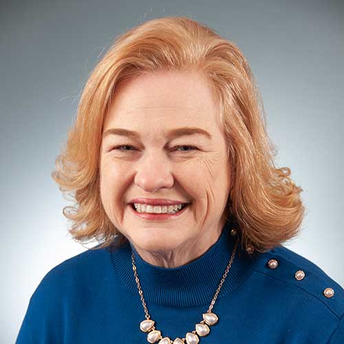 a woman wearing a blue shirt and smiling at the camera