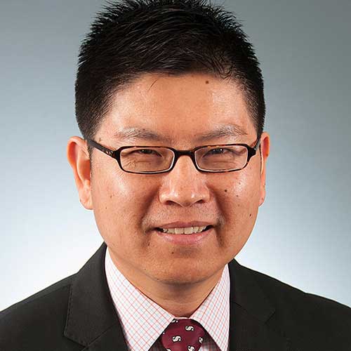 a man wearing glasses posing for the camera