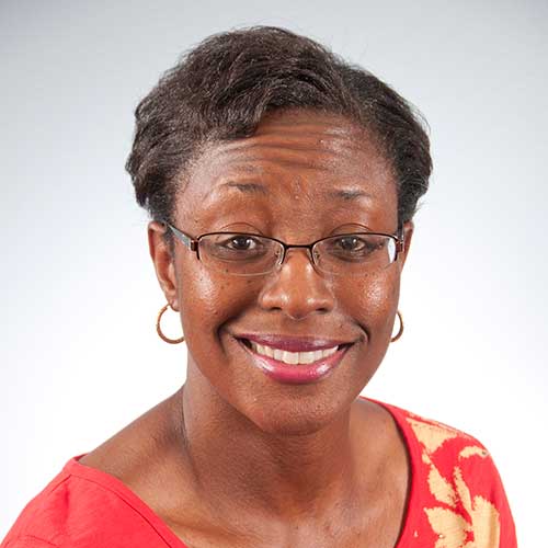 a person wearing glasses and smiling at the camera