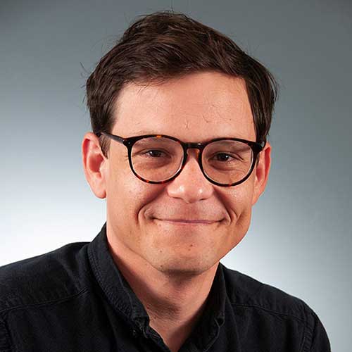 a man wearing glasses and looking at the camera