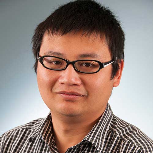 a man wearing glasses and smiling at the camera