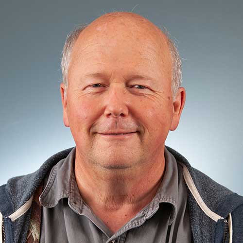 a man wearing glasses and smiling at the camera