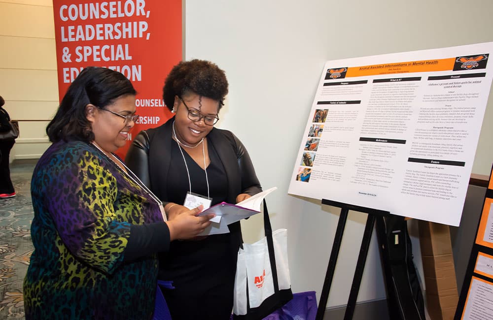 a man and a woman standing in front of a computer
