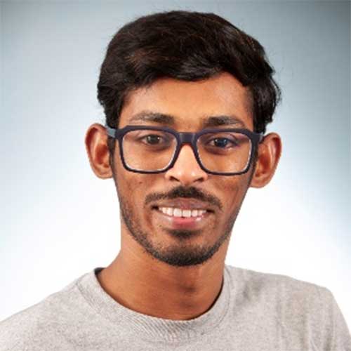 a man wearing glasses and smiling at the camera