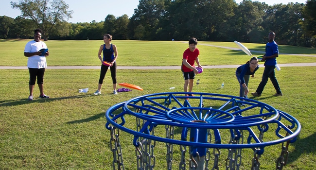 a group of people playing frisbee in a park