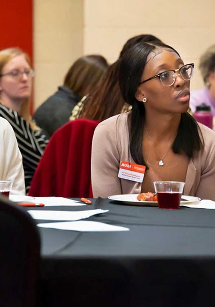 A Group Of People Sitting At A Table