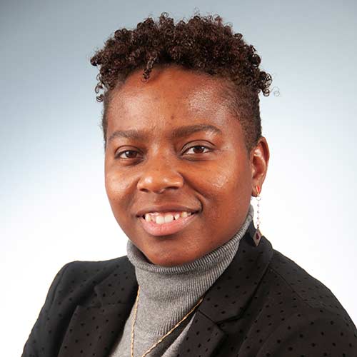 a man wearing a suit and tie smiling at the camera