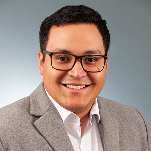 a man wearing glasses and smiling at the camera