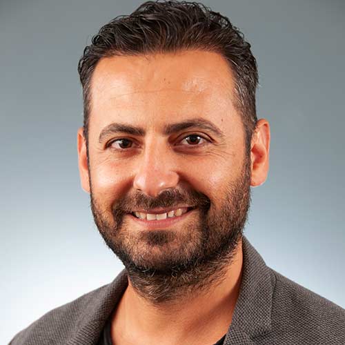 a man wearing glasses and smiling at the camera