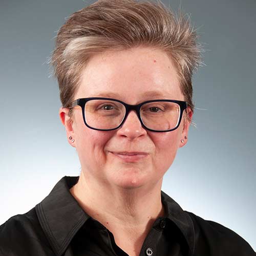 a man wearing glasses and smiling at the camera