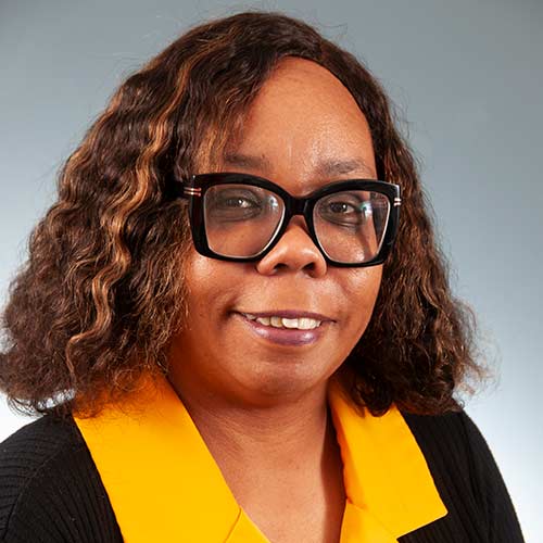 a person wearing glasses and smiling at the camera