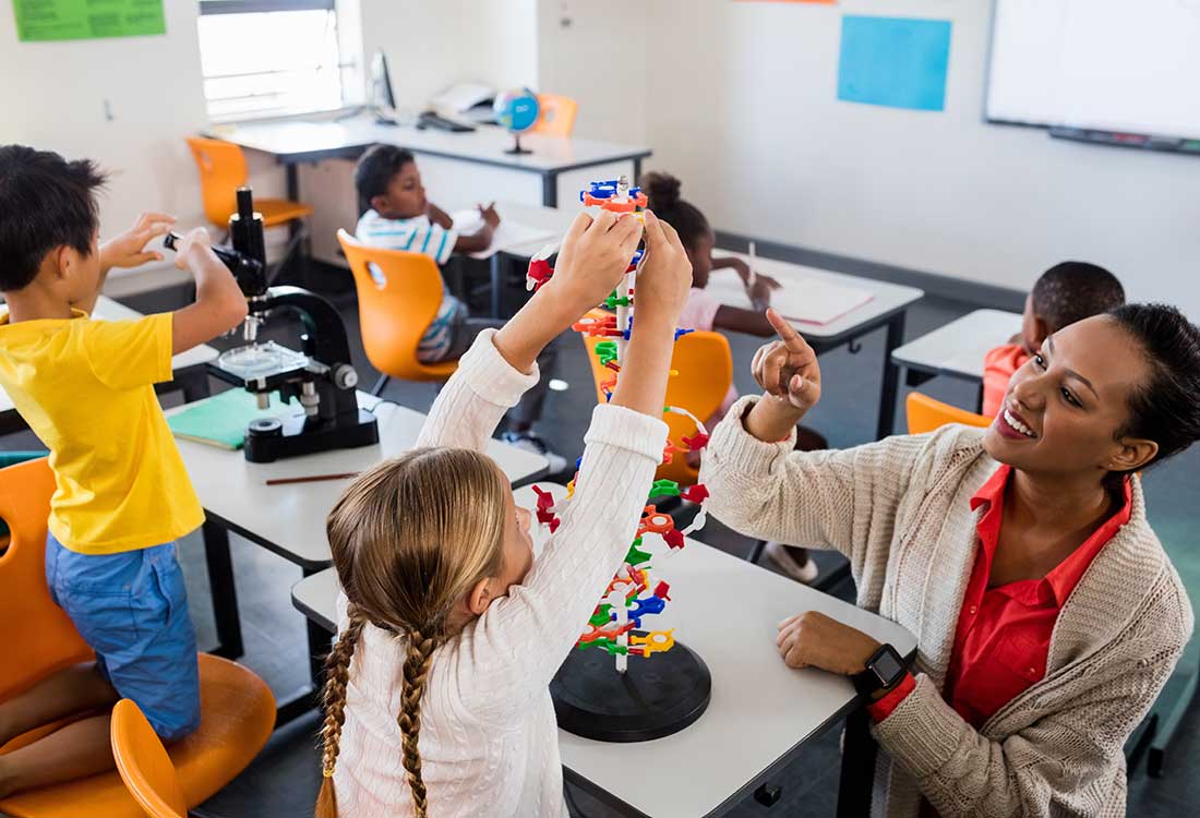 Young teacher working with a classroom of young children in a classroom
