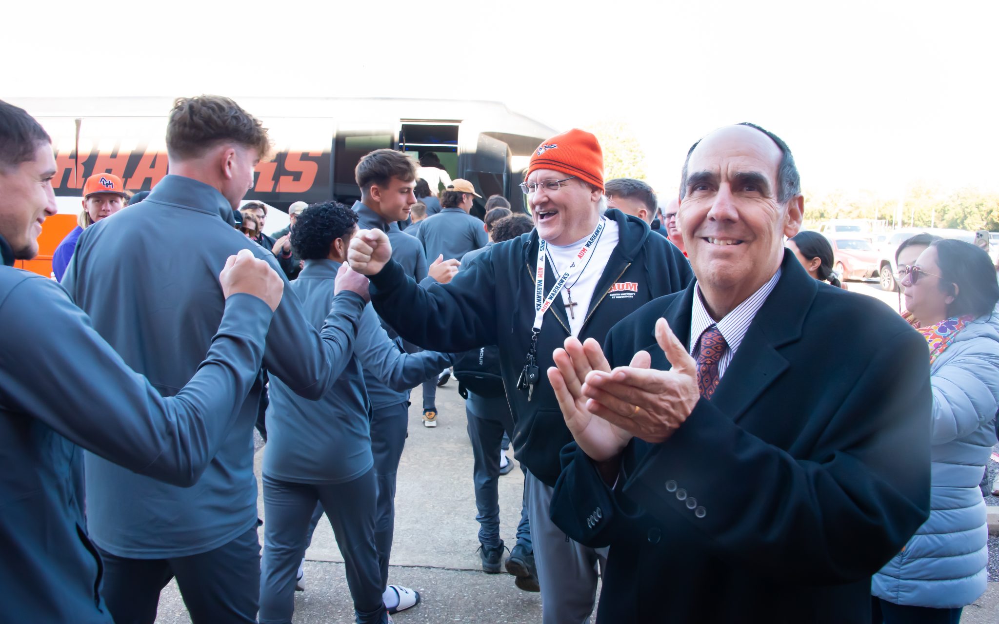 Dr. Carl Stockton cheers for men's soccer as they head off to a match.
